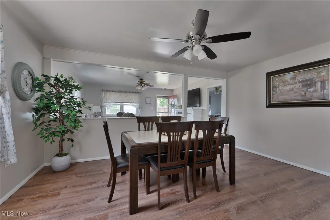 Dining area with ceiling fan and wood finished floors