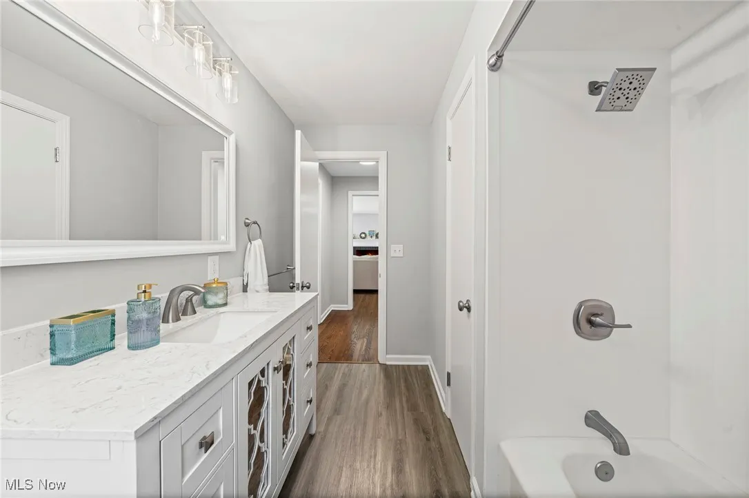 Full bathroom featuring vanity, wood finished floors, and shower / washtub combination