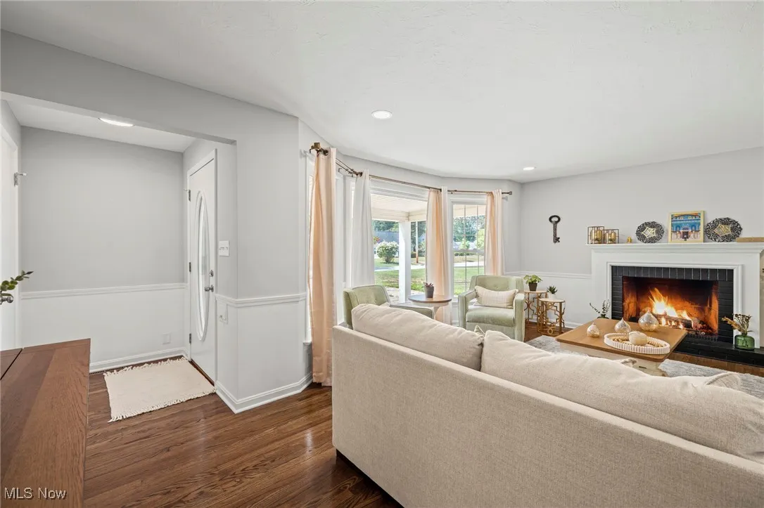 Living area featuring dark wood-type flooring, a fireplace, and recessed lighting