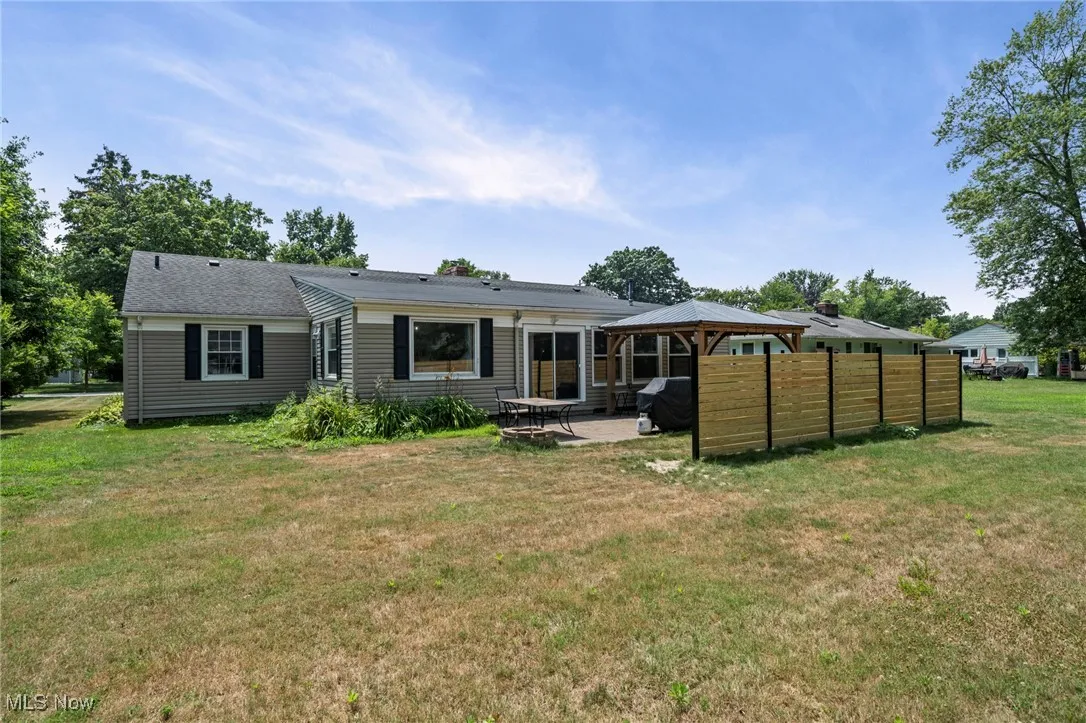 Rear view of house with a gazebo, a lawn, and a patio