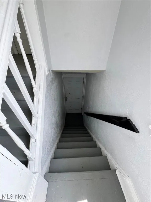 Staircase featuring a textured wall
