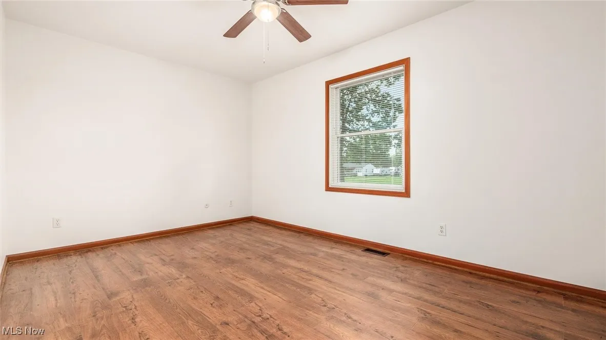 Empty room featuring wood finished floors and a ceiling fan