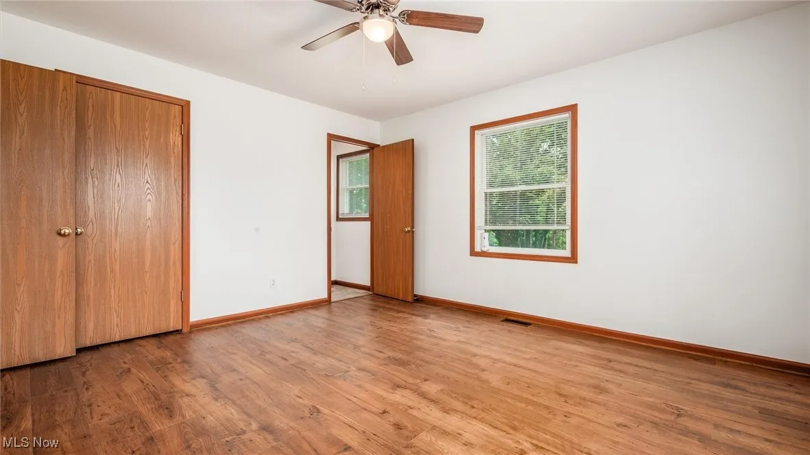 Unfurnished bedroom featuring wood finished floors, a closet, and ceiling fan