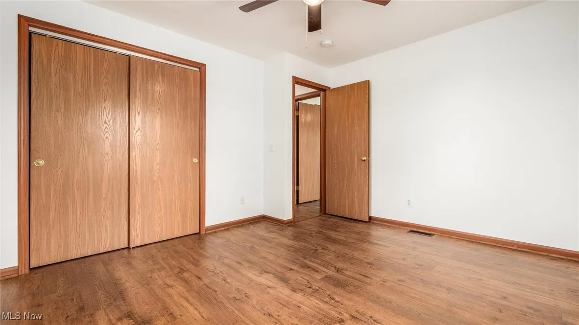 Unfurnished bedroom with wood finished floors, a closet, and ceiling fan