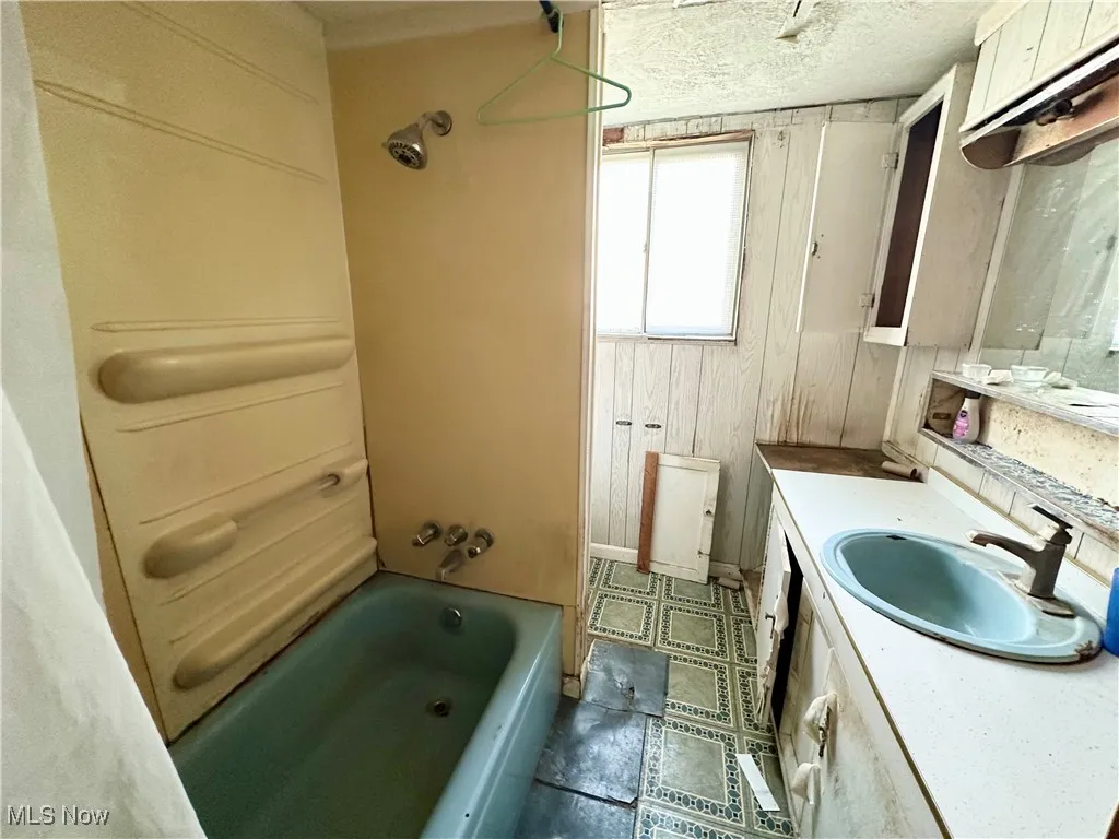 Full bath with vanity, and shower / washtub combination
