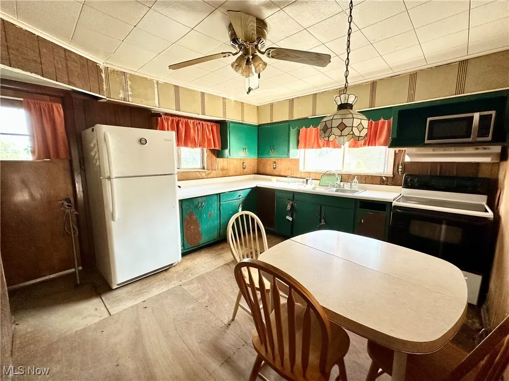 Kitchen featuring cabinets, refrigerator, electric range oven, and plenty of natural light