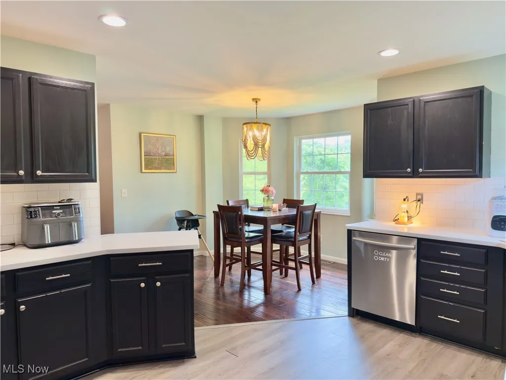 Kitchen featuring backsplash, dishwasher, light countertops, recessed lighting, and light wood-style floors