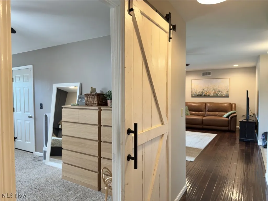 Corridor featuring a barn door and baseboards