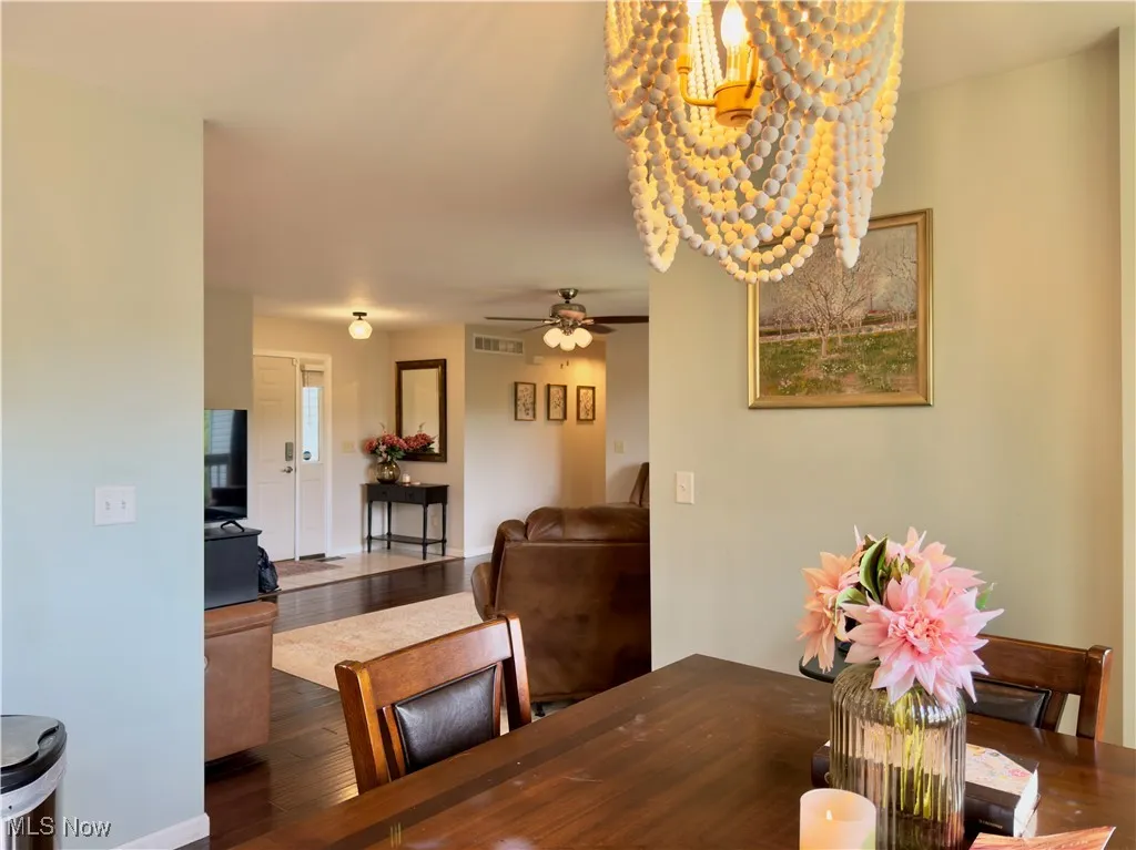 Dining space with a chandelier, wood finished floors, and a ceiling fan