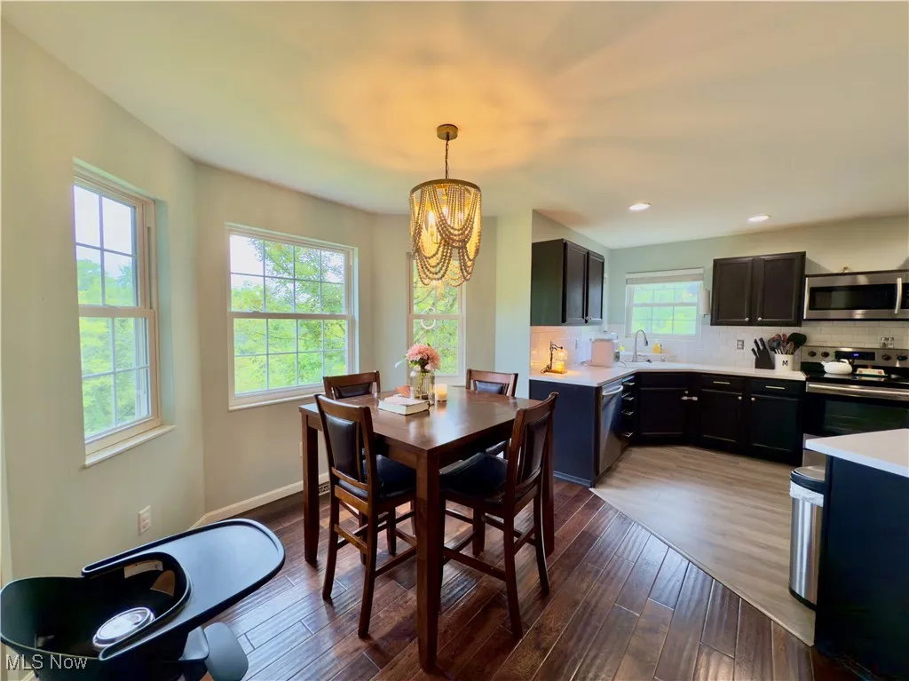 Dining area featuring dark wood finished floors, a chandelier, and recessed lighting