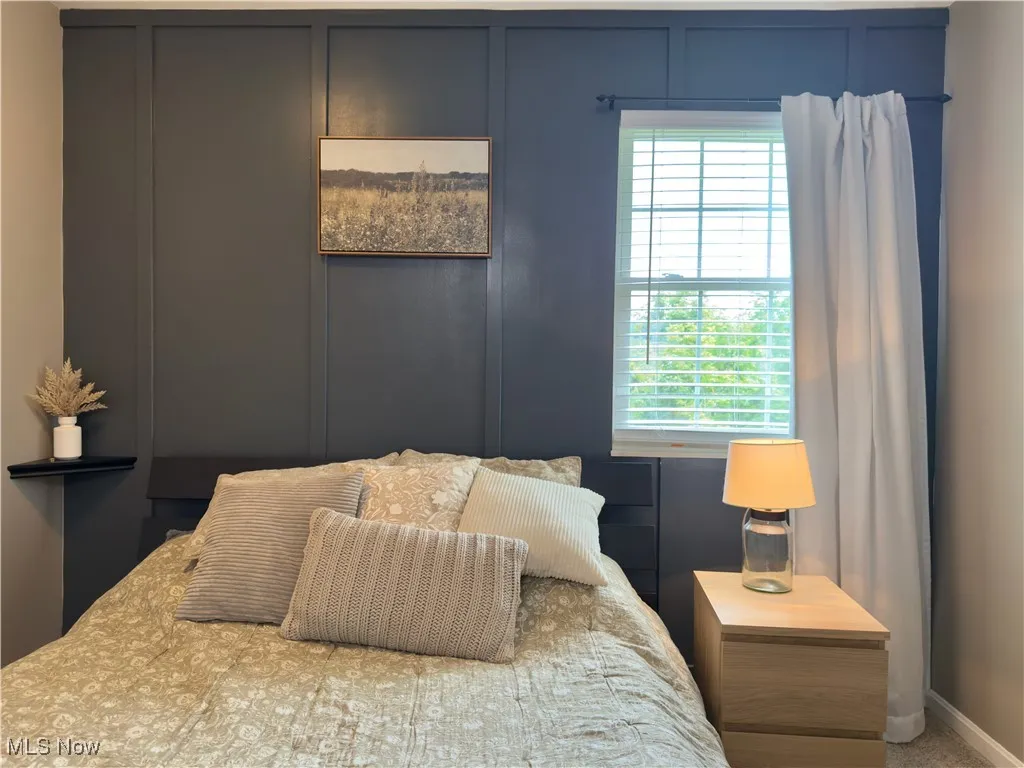 Bedroom featuring a decorative wall
