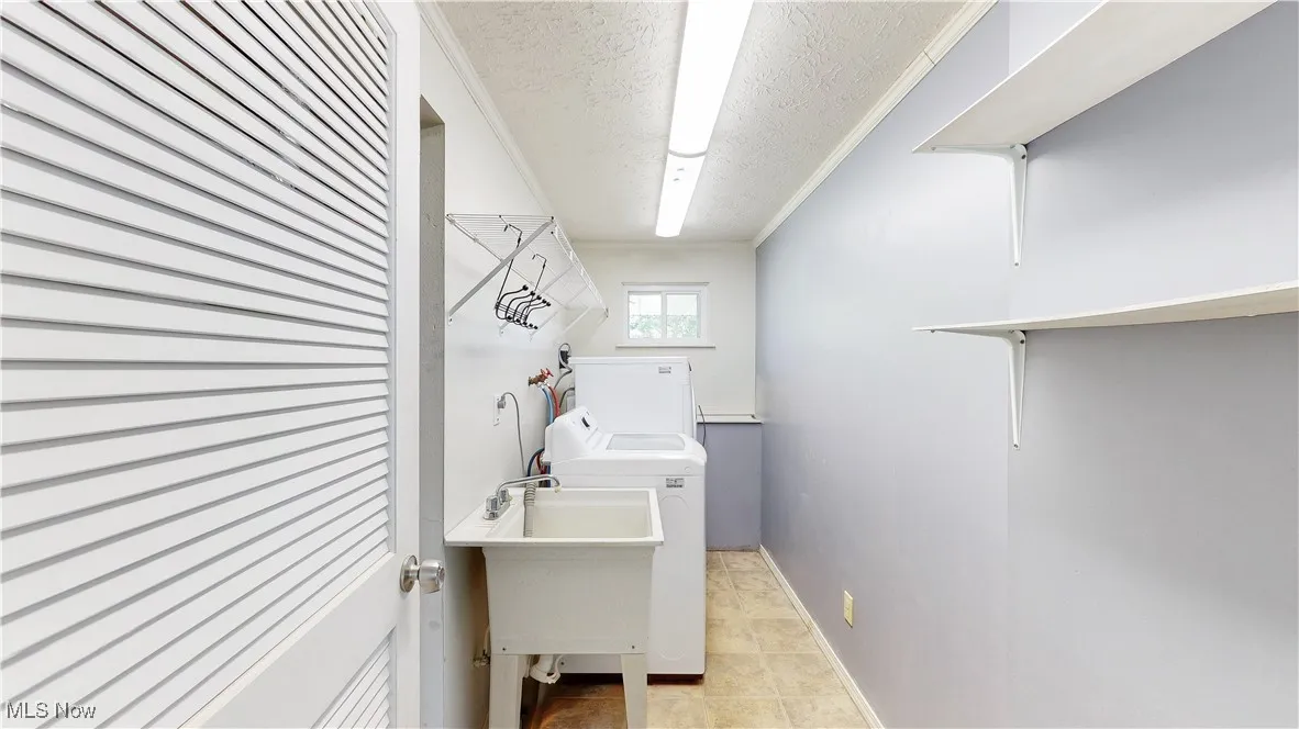 LAUNDRY ROOM WITH UTILITY SINK AND UPDATED WASHER/DRYER.