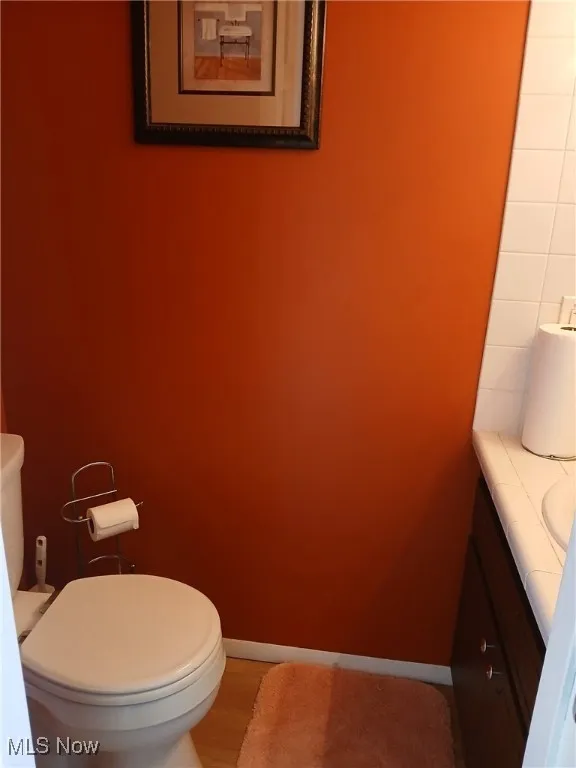 Half bath featuring vanity and wood finished floors