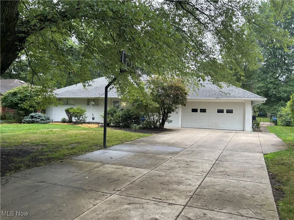 Single story home with roof with shingles, concrete driveway, and a garage