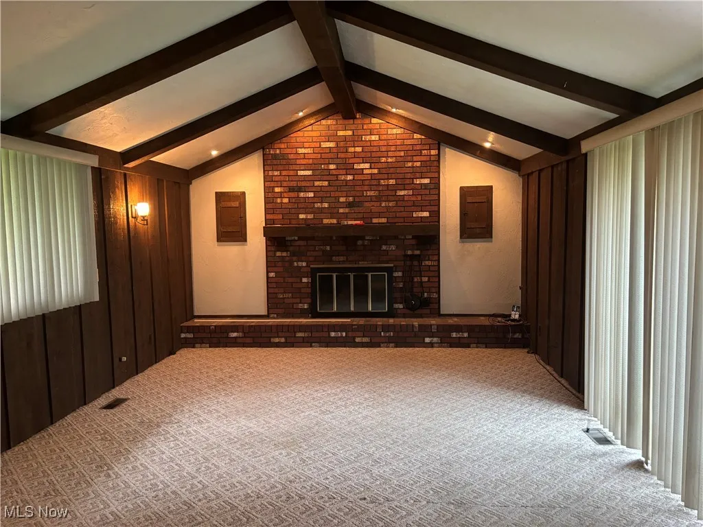 Family room featuring carpet, wooden walls, and a fireplace