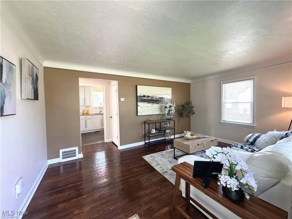 Living area featuring dark wood-style floors and a textured ceiling