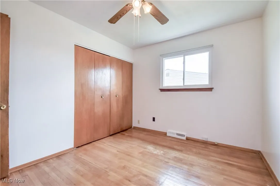 Unfurnished bedroom featuring light wood-style flooring, a closet, and ceiling fan