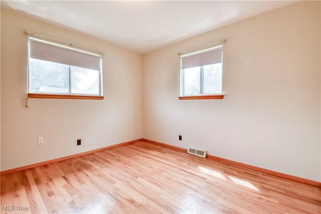 Unfurnished room featuring light wood finished floors and baseboards
