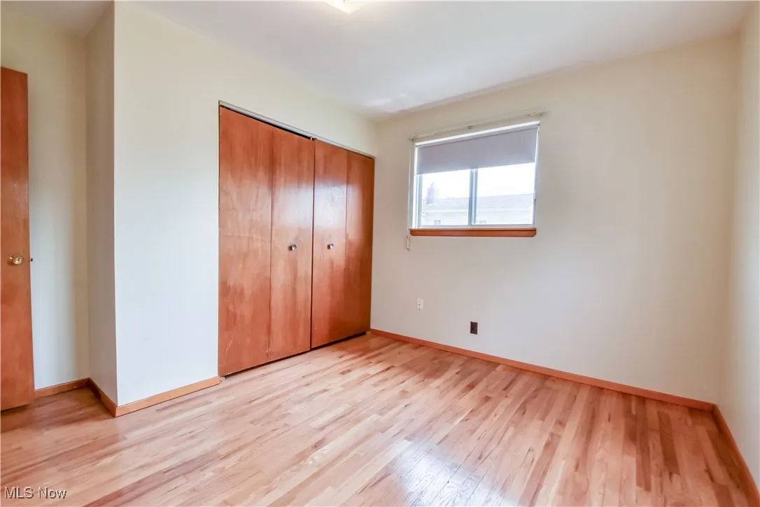 Unfurnished bedroom with light wood-style floors and a closet