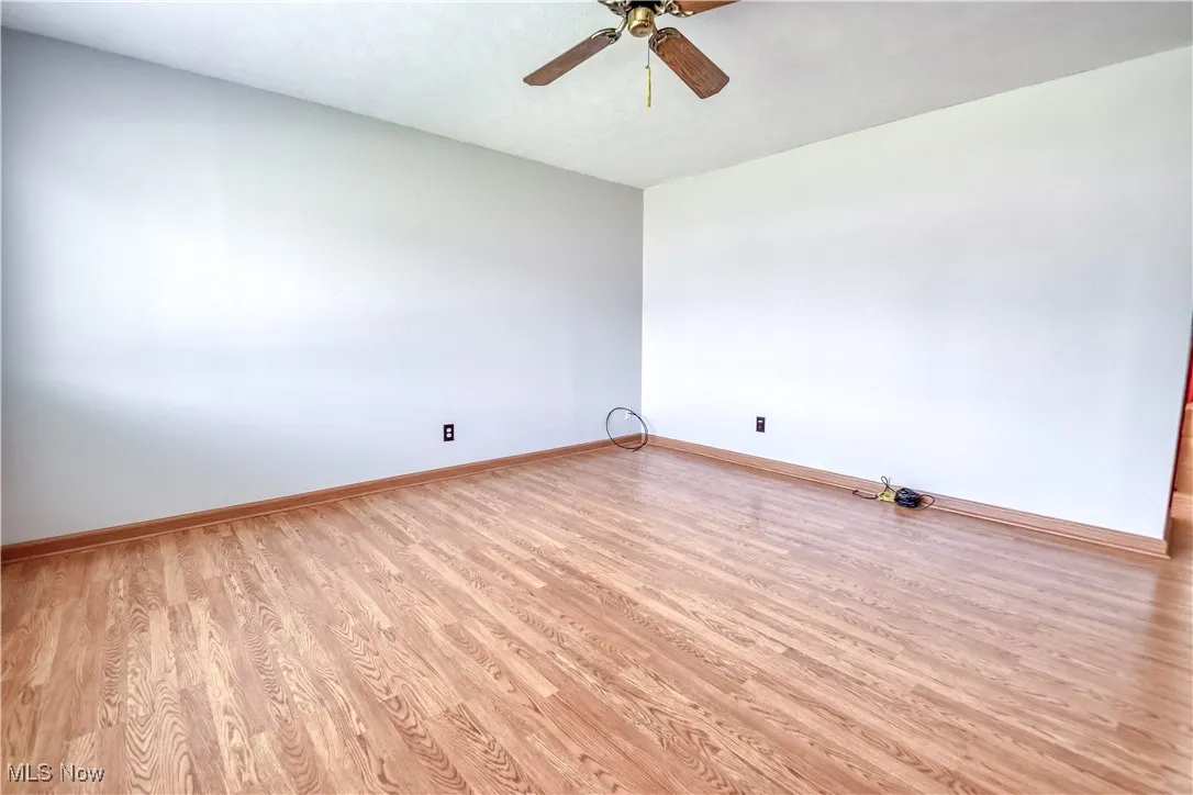 Empty room featuring light wood-style floors and ceiling fan