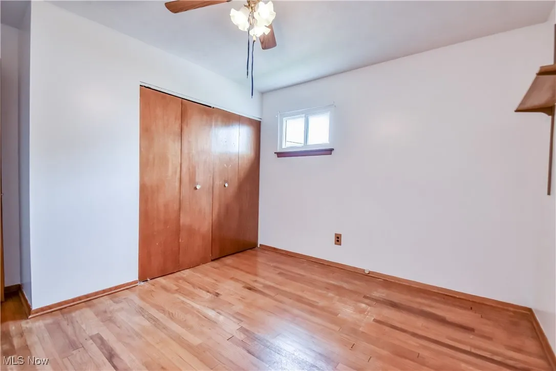 Unfurnished bedroom with light wood finished floors, a closet, and a ceiling fan