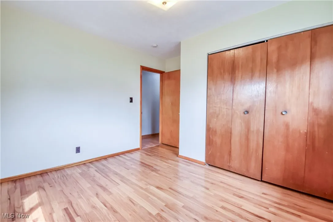 Unfurnished bedroom with light wood finished floors and a closet