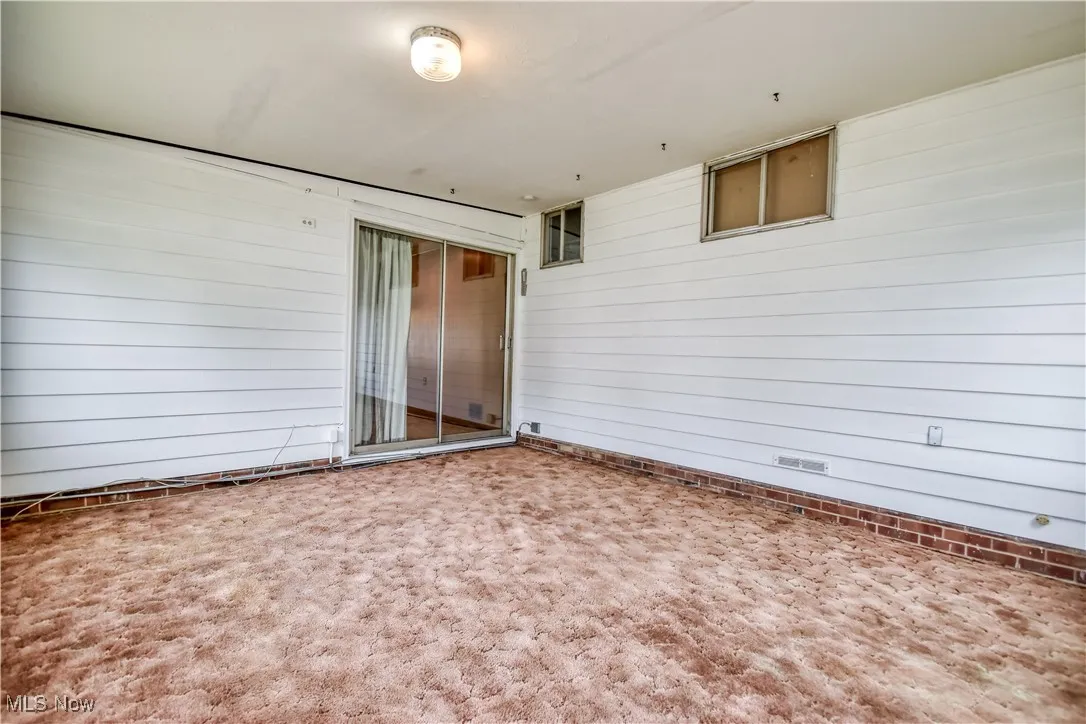Empty room with wood walls and carpet floors