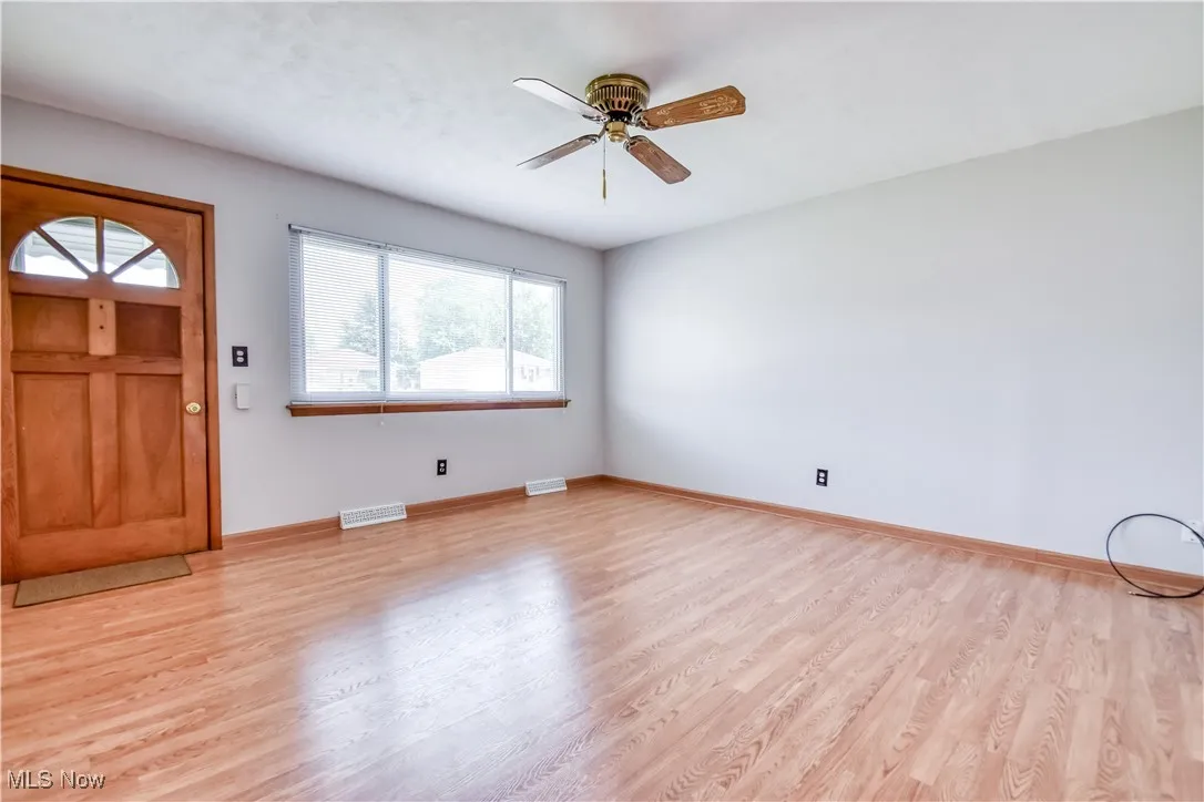 Foyer entrance with light wood-style floors and ceiling fan