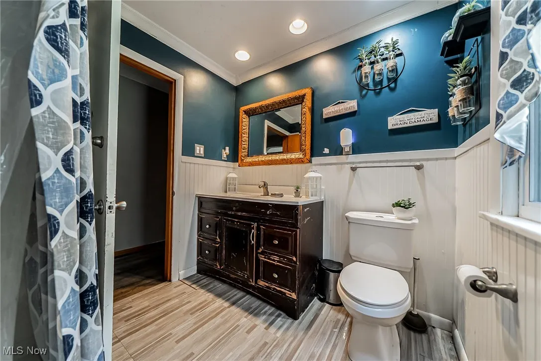  Full bathroom featuring crown molding, vanity, wood finished floors, recessed lighting, and a wainscoted wall