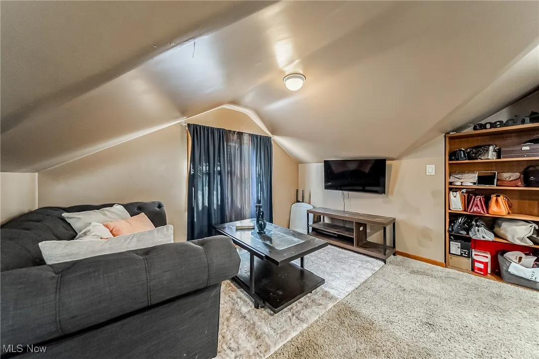 Additional sitting room with vaulted ceiling and carpet flooring