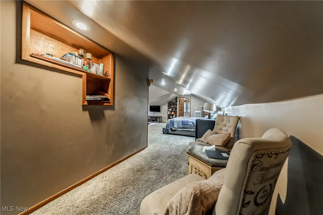 Carpeted bedroom featuring lofted ceiling and baseboards