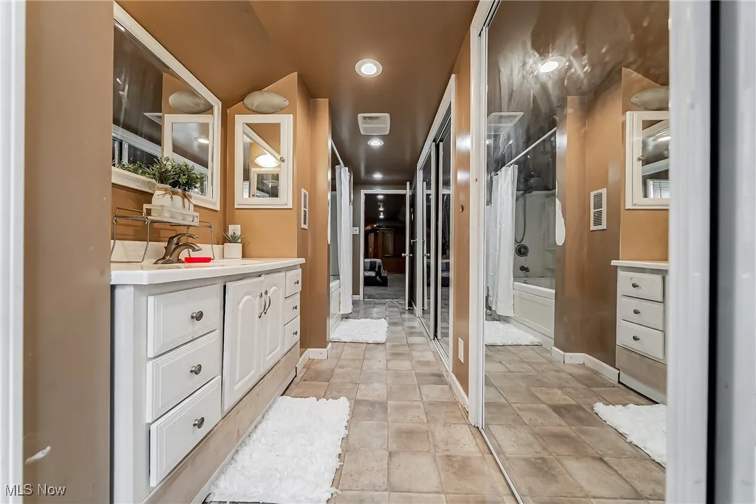 Full bath featuring vanity, bathtub / shower combination, recessed lighting, and tile patterned flooring
