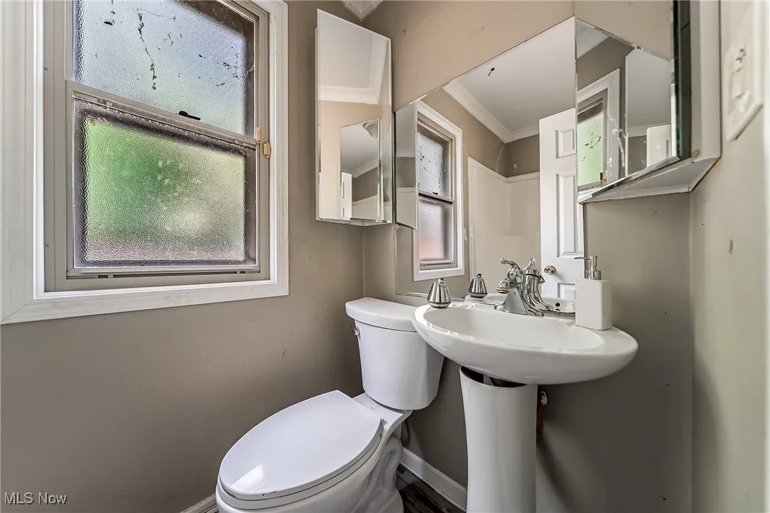 Full bath featuring crown molding, toilet and shower