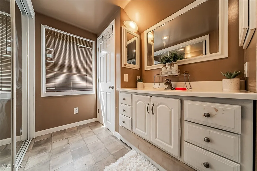 Full bathroom with vanity and tile patterned flooring