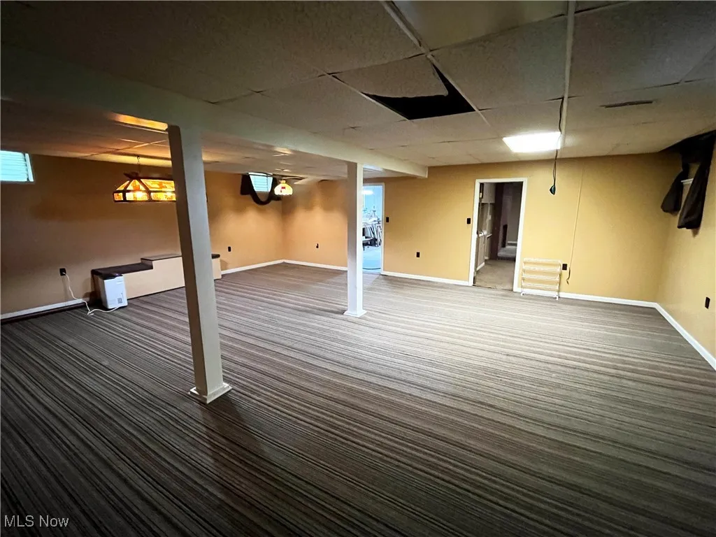 Basement with a drop ceiling and carpet
