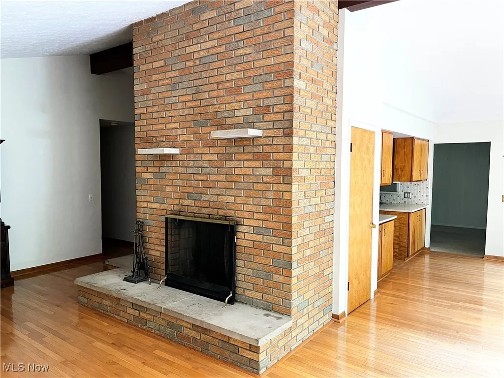 Unfurnished living room featuring a fireplace and light wood-style flooring