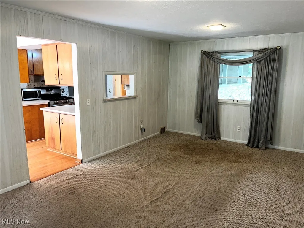 Unfurnished dining area featuring light colored carpet and a textured ceiling