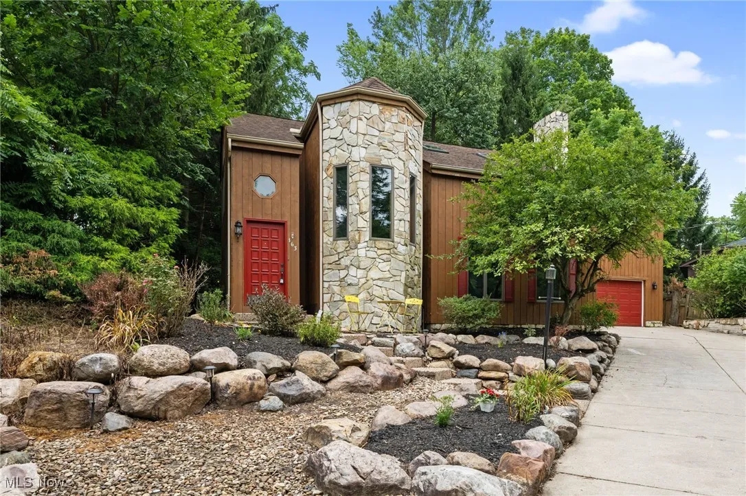 View of front of house featuring driveway, and stone siding