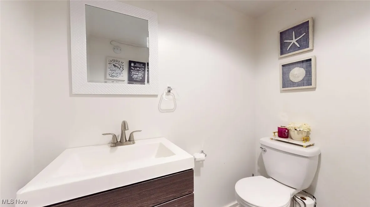 Half bath featuring toilet and vanity
