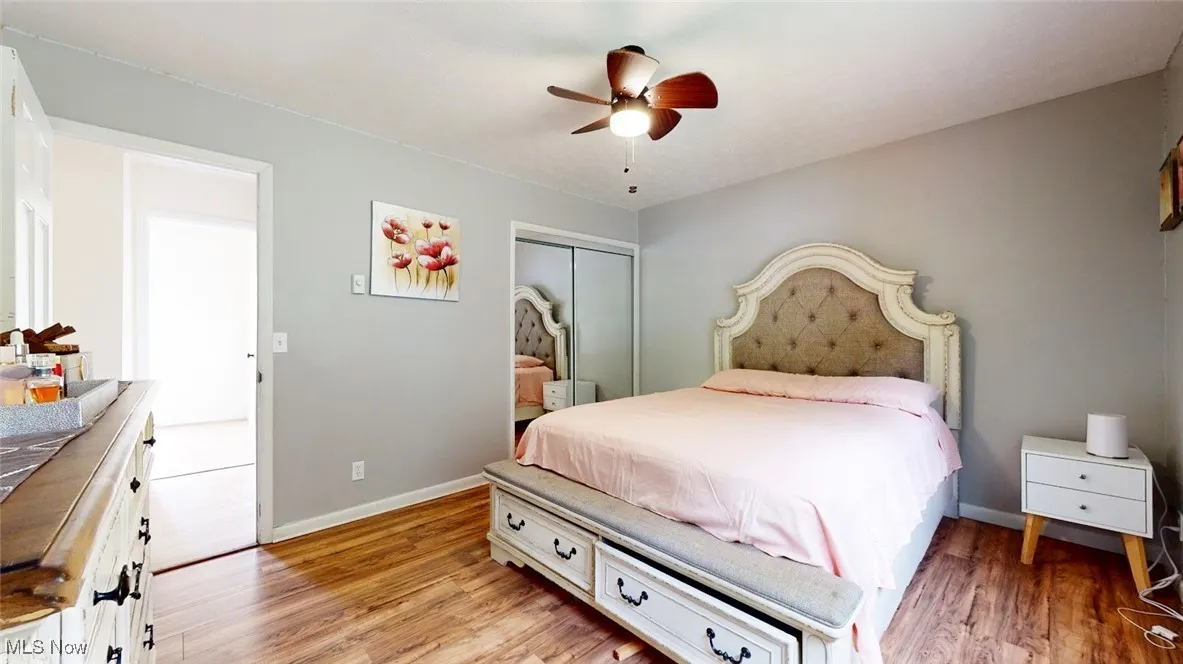 Bedroom with light wood-style flooring, a closet, and a ceiling fan