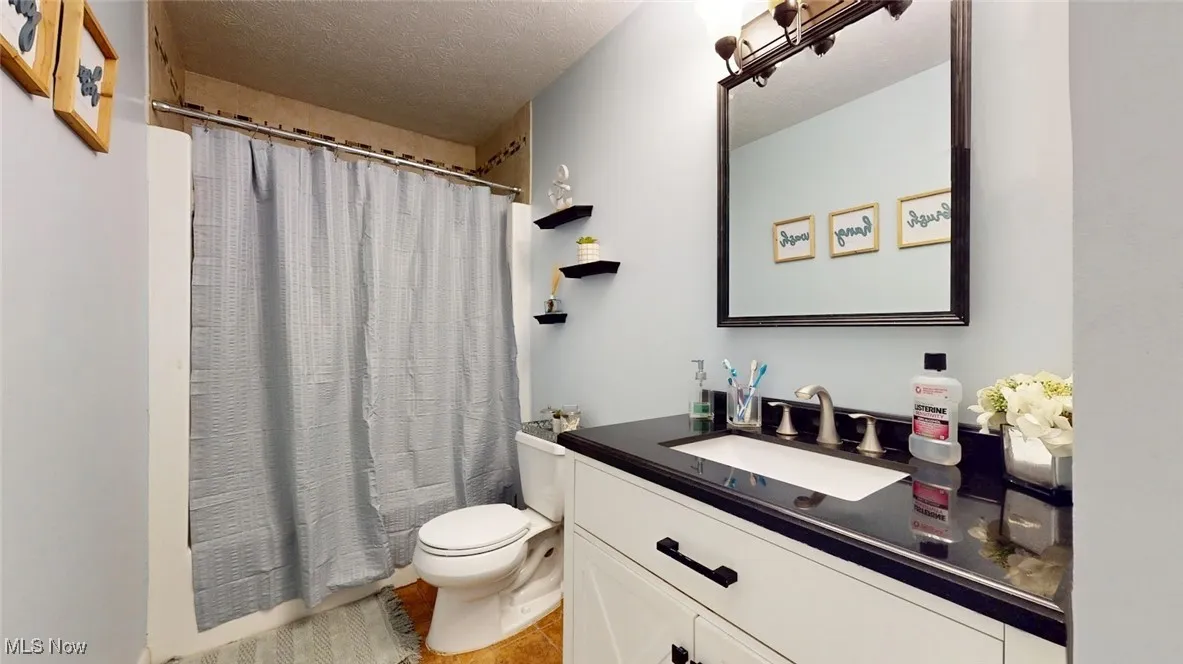 Full bath featuring vanity and tile patterned flooring