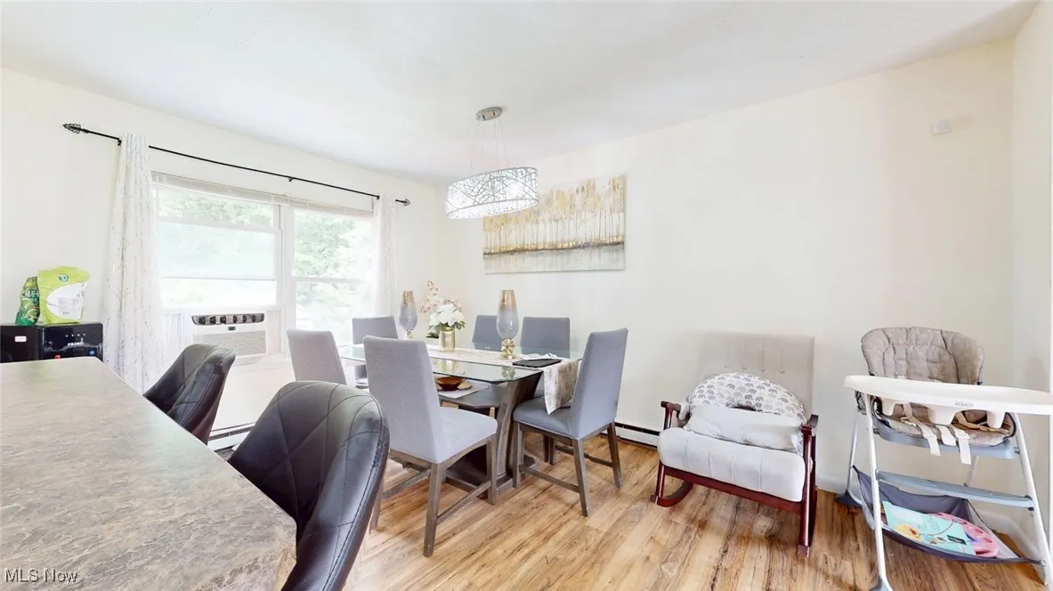 Dining room featuring wood finished floors and baseboard heating