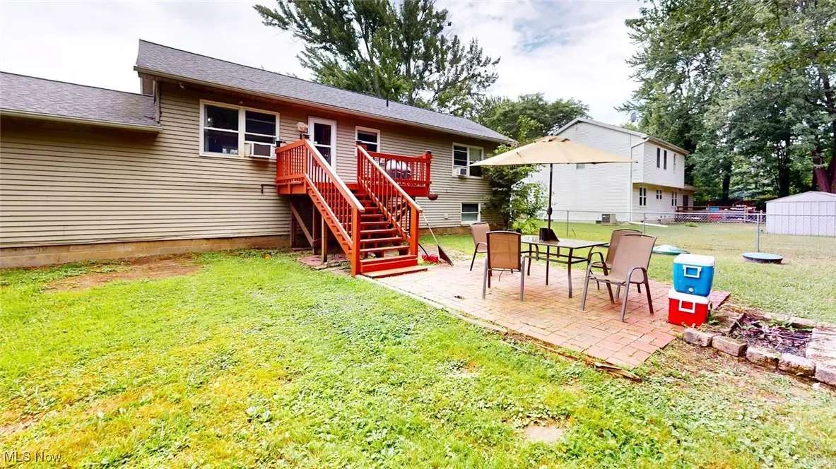 Rear view of house featuring stairway, a patio area and a wooden deck