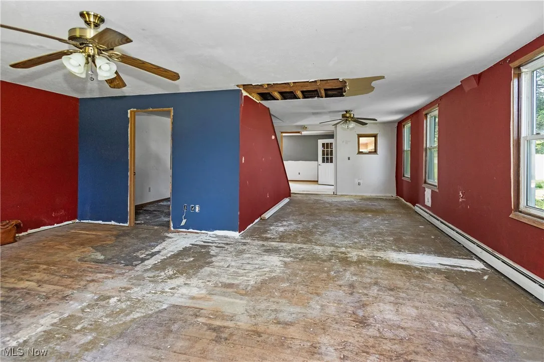 Spare room with a ceiling fan and a baseboard radiator