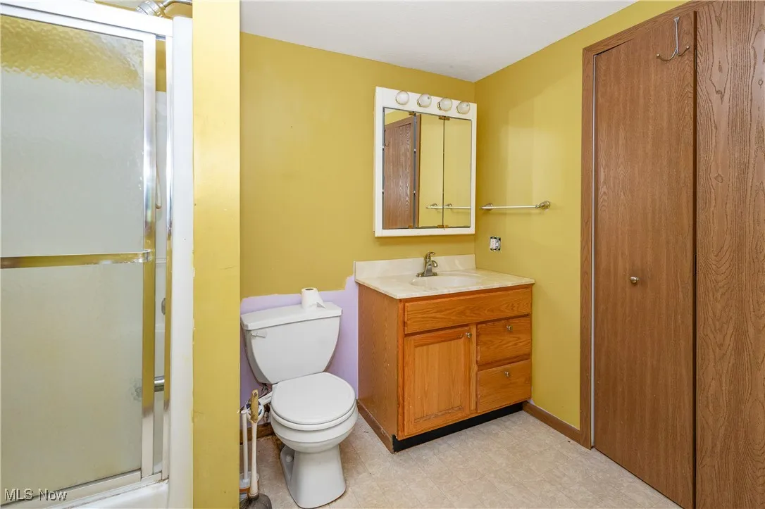 Bathroom featuring vanity, a shower with door, and tile patterned floors