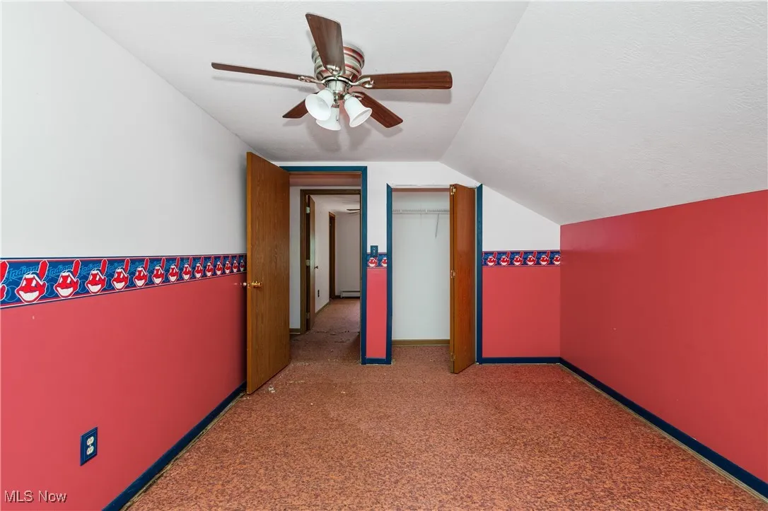 Additional living space with lofted ceiling, carpet flooring, ceiling fan, and a textured ceiling