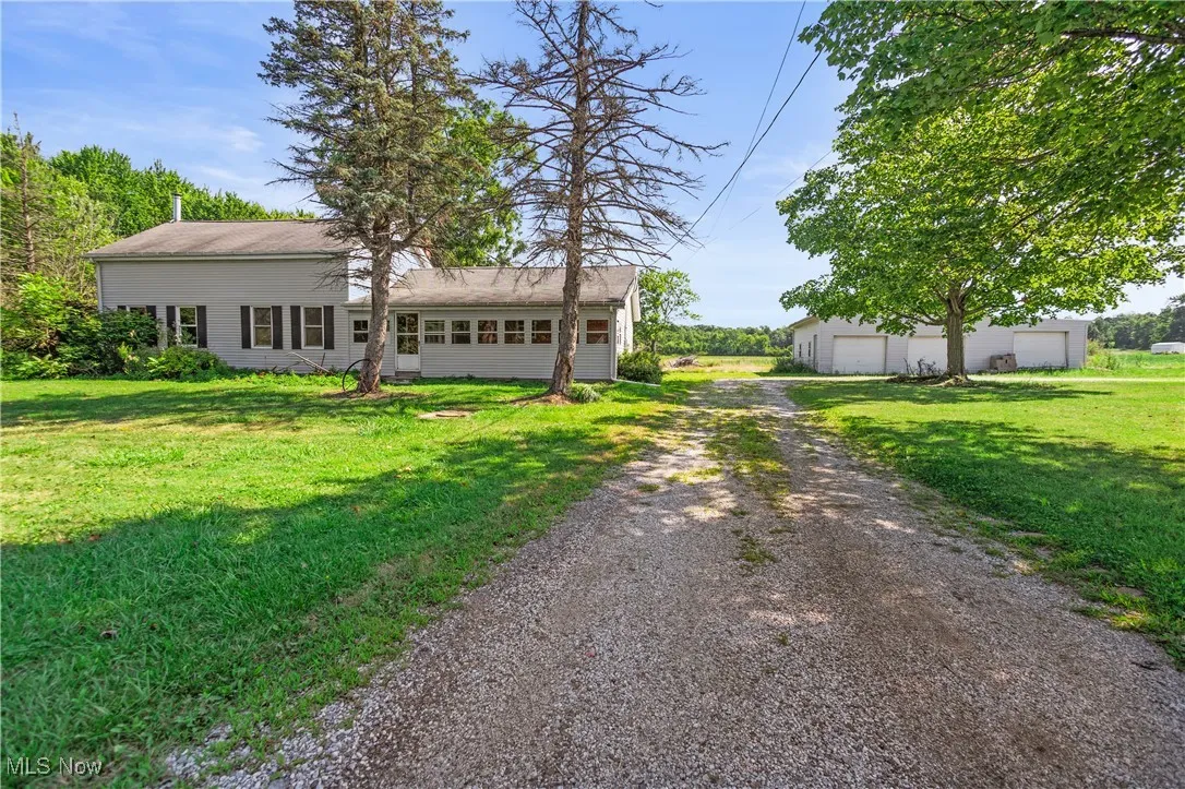 View of front of property featuring a front lawn, a garage, and driveway