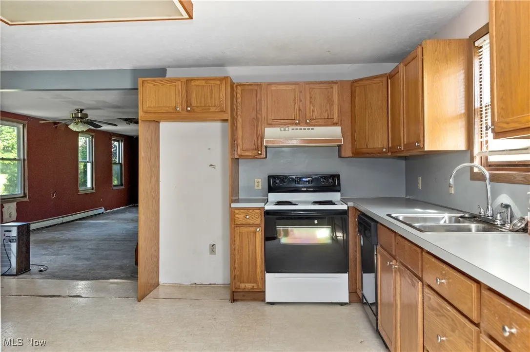 Kitchen featuring electric range, light countertops, under cabinet range hood, brown cabinets, and dishwasher