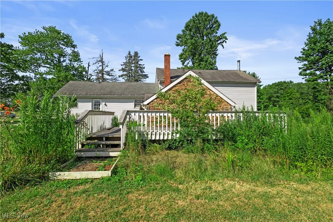 Rear view of property featuring a wooden deck and a chimney