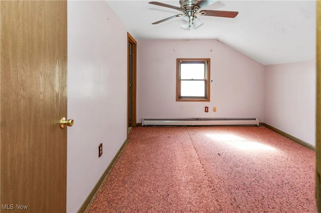 Bonus room with carpet flooring, vaulted ceiling, a baseboard heating unit, and a ceiling fan